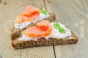 sandwiches on bread with salmon and basil on board