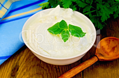 yogurt in a white bowl with a wooden spoon