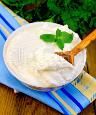 yogurt in a white bowl with a wooden spoon and mint