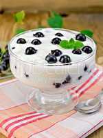 yogurt is thick with black currants and spoon on the board
