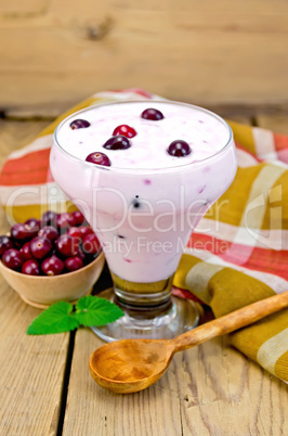 yogurt thick with cranberries and spoon on the board