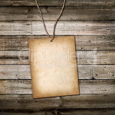 vintage cardboard card on a rope. wooden background