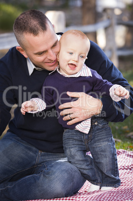 infant boy and young military father play in the park