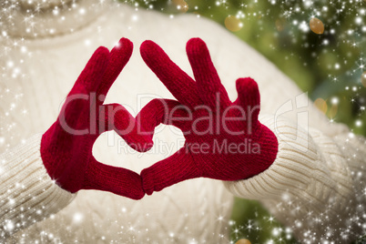 woman wearing red mittens holding out a heart hand sign