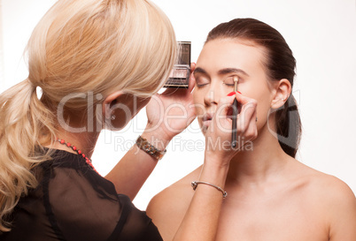 beautician applying eye makeup