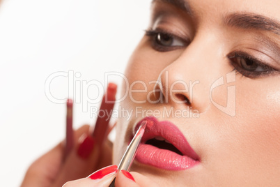 young woman having lip gloss applied