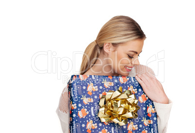 woman holds a gift wrapped in christmas paper