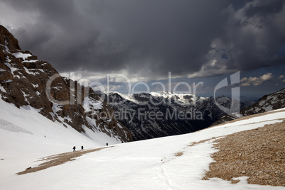 group of hikers in snowy mountains before storm