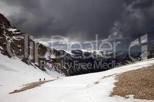 group of hikers in snowy mountains before storm