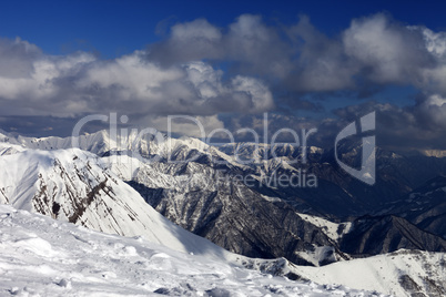 winter sunlit mountains in clouds