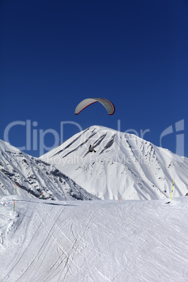 skydiver in sunny snowy mountains