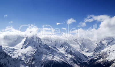 panorama of snowy mountains in clouds