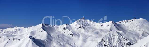 panoramic view on off-piste slopes and blue sky at nice day