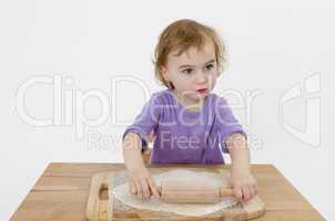 child rolling out dough