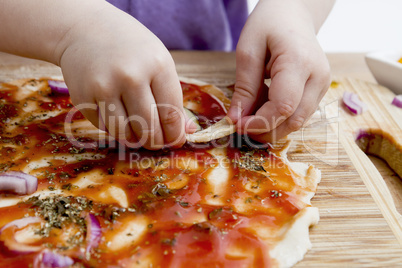 small hands preparing pizza