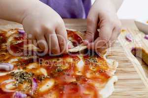 small hands preparing pizza