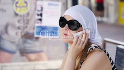 woman in a headscarf chatting on mobile