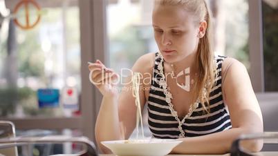 young woman eating spaghetti.