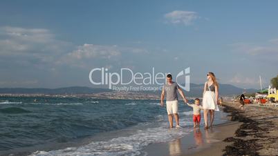 young family walking on the beach