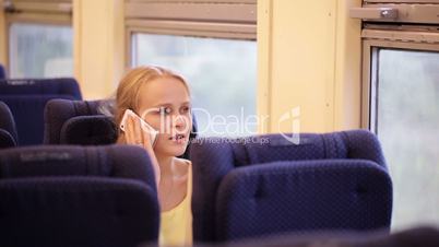 woman talking on the phone being on the train.