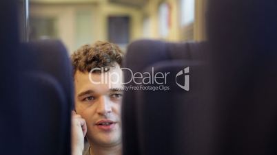 Man talking on the phone in train.