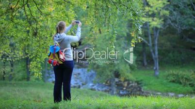 Woman taking pictures of nature scenes.