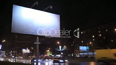 Time lapse of urban scene with an empty billboard, by night