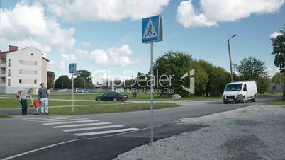 Family of three crossing the road.