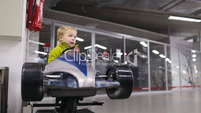 Little boy driving a racing car