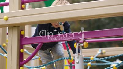 Little boy climbing playground equipment.