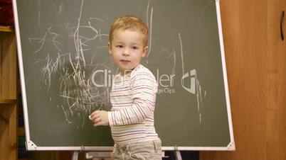creative little boy drawing on a chalkboard