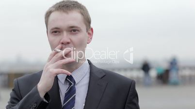 Businessman thinking while smoking a cigarette