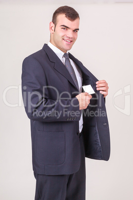 Geschäftsmann nimmt lächelnd eine Visitenkarte aus dem Jackett