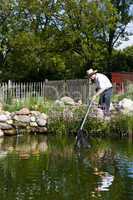 man fishes in garden pond