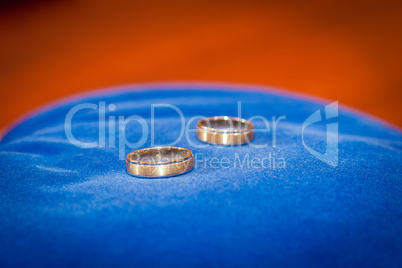 couple of gold wedding rings on blue