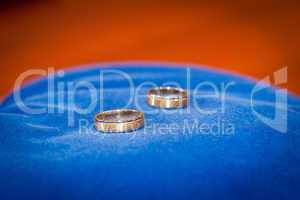 couple of gold wedding rings on blue
