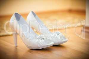 bride's white shoes on the floor