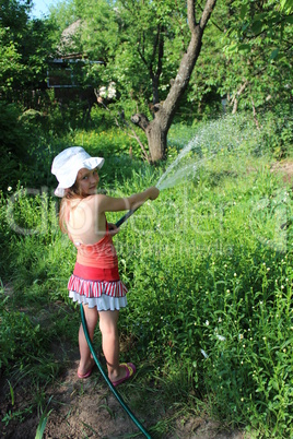 girl watering a kitchen garden