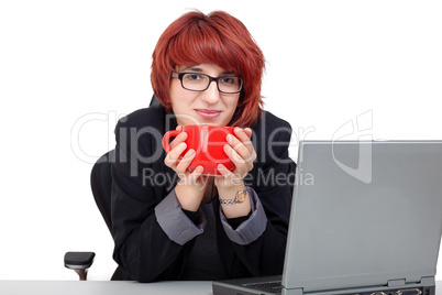 woman sitting on laptop and drinking from the cup