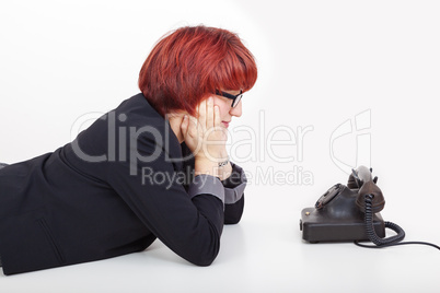 woman lying on her stomach in front of the phone
