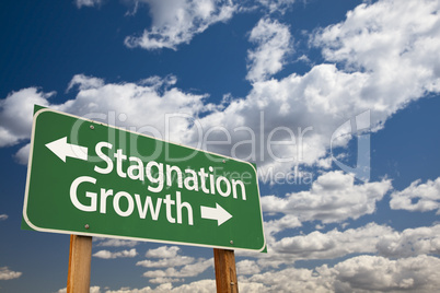 stagnation or growth green road sign over clouds and sky