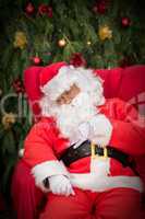 sleeping santa clause on red christmas armchair