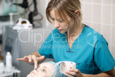 nurse in a skin clinic applying protective cream