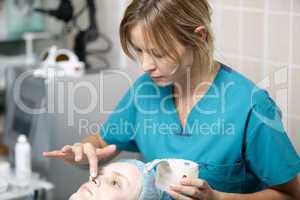 nurse in a skin clinic applying protective cream