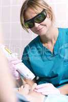smiling practitioner doing a laser treatment