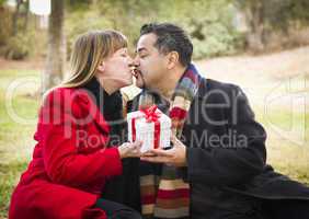 mixed race couple sharing christmas or valentines day gift outsi