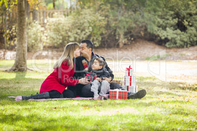 mixed race family enjoying christmas gifts in the park together