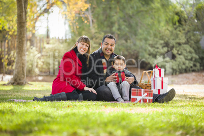 mixed race family enjoying christmas gifts in the park together