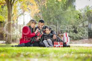happy mixed race family enjoying valentine's gifts at park together