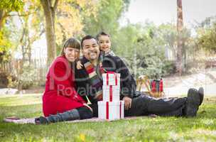 mixed race family enjoying christmas gifts in the park together